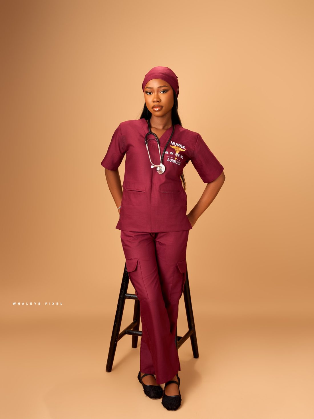 Victoria Agunloye, Registered Nurse, in maroon scrubs with a stethoscope